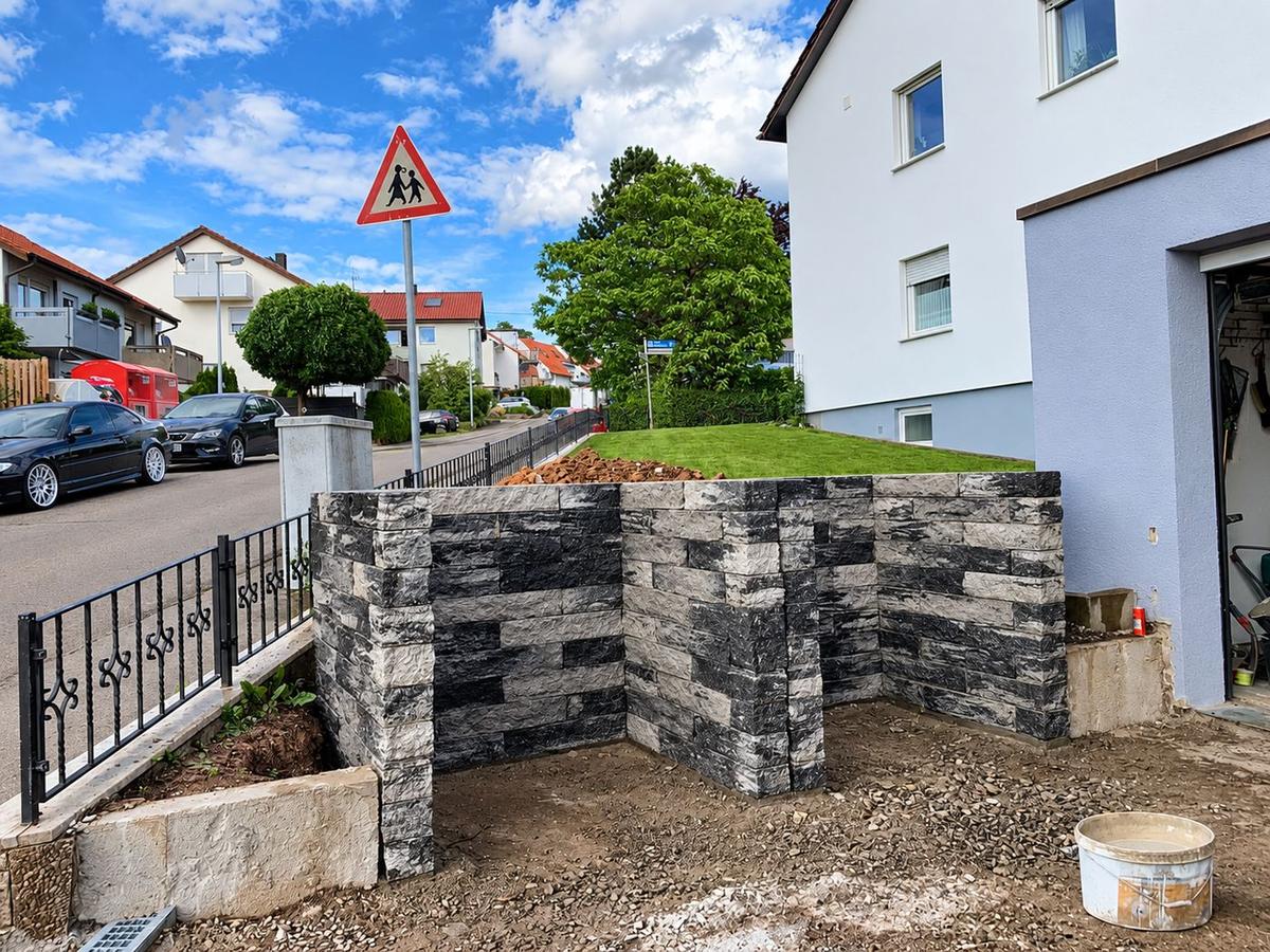 Neue Mauer aus Mauersteinen am Hang